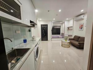 Long BìnhNhà Đẹp Vinhomes Grand Park的一个带水槽的厨房和一张沙发