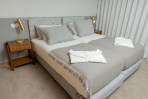 辛方伊什QUINTA ALTO DO RIO的卧室配有一张带白色床单和枕头的大床。