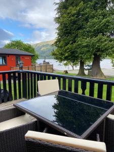 罗厄德南Cozy Cabin with Stunning Loch Lomond Views的树上阳台的桌椅