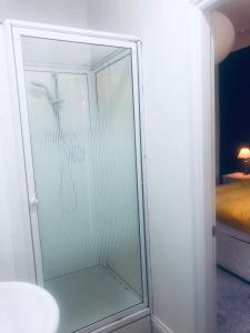 利兹Beechwood Accommodation in North Leeds的一个带床的房间的玻璃淋浴间门