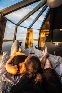 罗瓦涅米Vikajärvi Lake View Experience Igloos的躺在船上床上的女人