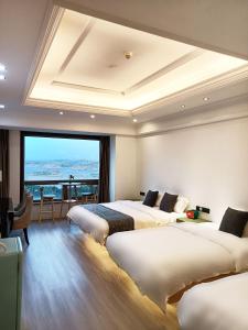 平潭平潭宇诚海景蓝眼智能酒店的酒店客房设有三张床和大窗户
