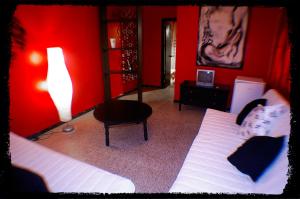 莱佩Pensión El Alamo的红色卧室配有床和椅子