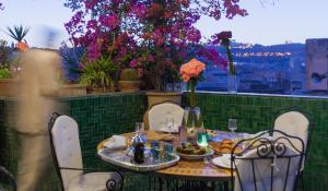 非斯里亚德拉梅森韦尔特酒店的鲜花阳台的桌椅
