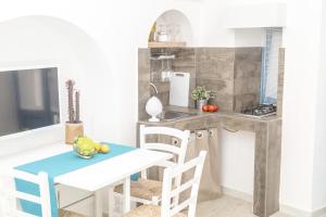 莫诺波利Borgo Albergo Capozzi 39的厨房配有桌椅和柜台。