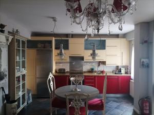 巴利亚多利德Apartamento San Quirce - céntrico y reformado- wifi y netflix的厨房配有红色橱柜和桌椅