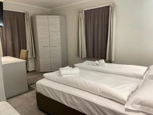 蒙法尔科内Antica locanda al Gelso的配有白色床单的酒店客房内的两张床
