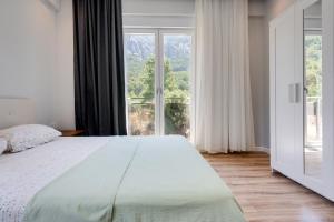 安塔利亚Begonvilla Apart Karaöz的一间卧室设有一张大床和一个大窗户