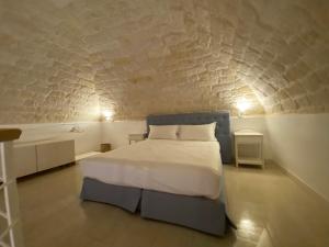 曼弗雷多尼亚A Casa del Console apartment的卧室配有白色的床和砖墙
