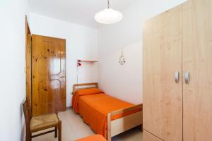 托雷瓦多VistaMare Paradiso的一间小卧室,配有橙色的床和橱柜