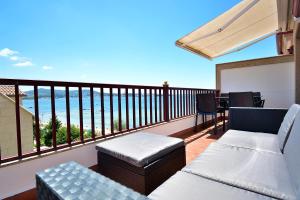 维拉加尔西亚·德·阿劳萨Ático con terraza y vistas al mar en Vilagarcía的阳台配有两张沙发和一张桌子及椅子。