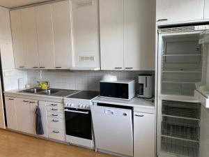 科沃拉kauppalankatu kolmio的厨房配有白色橱柜、水槽和微波炉