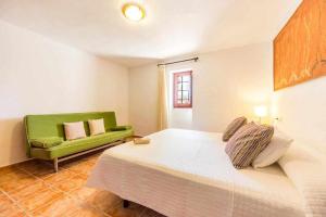 阿尔盖达Finca Cas Contador Mallorca的一间卧室配有一张床和一张绿色沙发