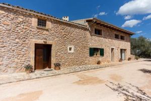 阿尔盖达Finca Cas Contador Mallorca的一座大型石头建筑,前面有一扇门