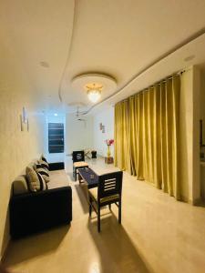 勒克瑙Atulyam Stays Sushant Golf City的客厅配有沙发和桌子