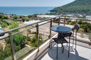 安塔利亚Begonvilla Apart Karaöz的俯瞰大海的阳台配有一张桌子和两把椅子
