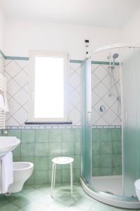 伊斯基亚拉卢纳酒店的带淋浴、卫生间和凳子的浴室