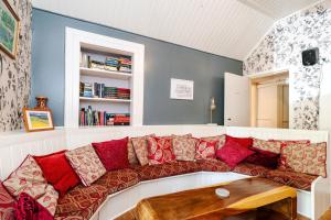 洛亨黑德Mansewood Country House的客厅配有红色枕头的沙发
