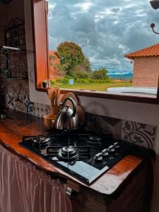 圣托梅-达斯莱特拉斯Chalés Bela Vista的厨房内的炉灶上方的茶壶