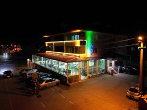 萨卡里亚Kocaali Sun Otel的一座建筑,晚上有汽车停在外面