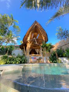 乌布Wahem Eco Bamboo的一座带游泳池的度假村,位于一座房子旁边