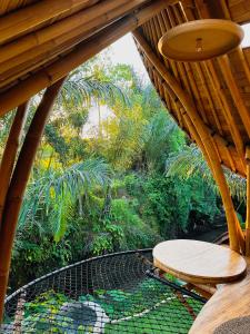 乌布Wahem Eco Bamboo的木制屋顶,露台上配有桌子和长凳