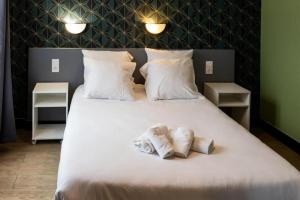 巴黎卢克西亚酒店的一张白色的大床,带两条毛巾
