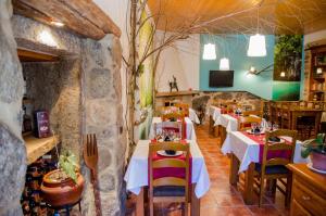 PorqueirósCasa As Fontes的一间带桌椅和石墙的餐厅