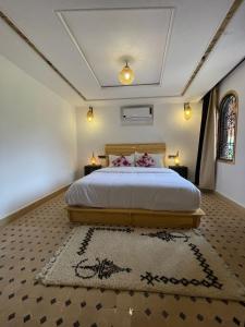 Aït IdaïrDar Rihana Dadès的一间卧室配有一张带两盏灯和地毯的床。
