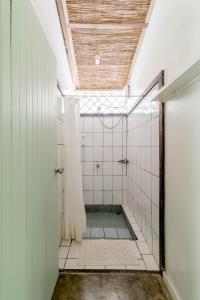 圣塔特蕾莎海滩Bajo el Arbol B&B的带淋浴的浴室和白色瓷砖墙壁
