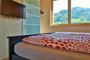 施科佩尔瑙Bergreich Appartement 4的一张带红色和白色棉被的床和一个窗户