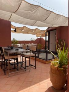 塔鲁丹特达尔兰迪嘎巴住宿加早餐旅馆的庭院配有桌椅和遮阳伞。