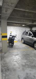 麦德林Apto zion的停放在汽车旁的带摩托车的停车库