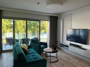 吉日茨科"Przystań u nas" Apartament Stranda B的客厅配有绿色家具和平面电视