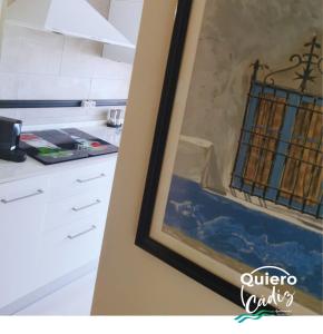 加的斯Quiero Cádiz的厨房墙上挂有绘画作品
