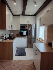 PrzerwankiDom Na Mazurach的厨房配有白色橱柜和不锈钢冰箱