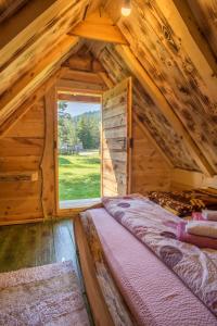 扎布利亚克Eco Camp Chalets pod Gorom的小木屋内的卧室设有大窗户