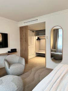 柏林ADELANTE Boutique Hotel的一间卧室配有一张床、一把椅子和镜子