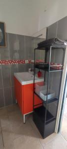 拉西约塔Chambre d'hôtes Chante Cigale的一间带水槽和红色橱柜的浴室