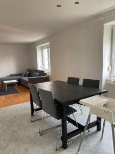 帕恩多夫Modernes Haus in Parndorf的客厅配有黑色的桌子和椅子