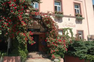 埃格尔罗曼缇卡埃格酒店的一座红色花的建筑的入口