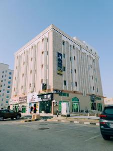 塞拉莱أجاويد Ajaweed的一座大型建筑,前面有停车位