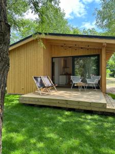 斯沃尔纳加西耶Camping Swory的小屋设有1个带2把椅子和1张桌子的甲板