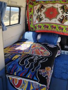 圣塔格鲁迪斯Casa movil的一张带毯子的面包车后面的床铺