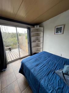 塞拉纳镇Casa CALMA en Villa Serrana的一间卧室设有蓝色的床和一个阳台