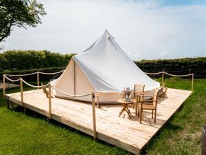 Cross InnHafod Hir的木制甲板上配有桌椅的白色帐篷
