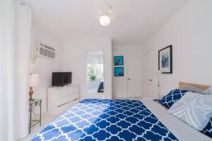 迈阿密海滩BEACH VIBES的卧室配有蓝色和白色的床和电视。