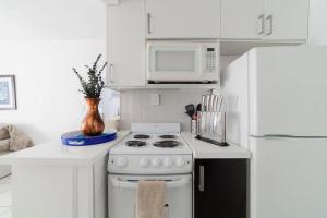 迈阿密海滩BEACH VIBES的白色的厨房配有炉灶和微波炉。
