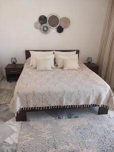 莫纳斯提尔Appartement en bord de mer的一间卧室配有一张大床,墙上挂有枕头和帽子