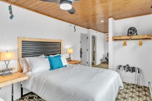 安克雷奇Highliner Hotel - Deluxe Double Queen with Mountain View的卧室设有白色的床和木制天花板。